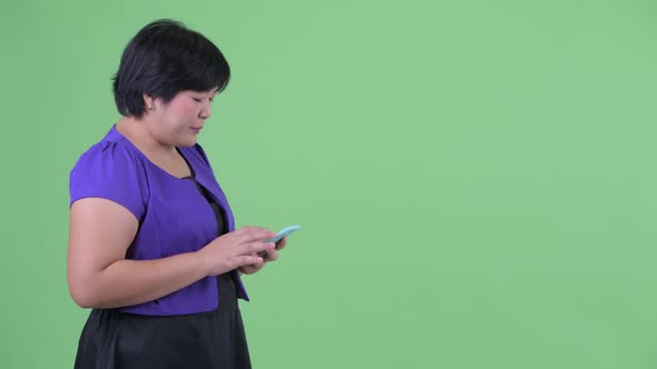 Happy Young Overweight Asian Woman Waiting While Using Phone