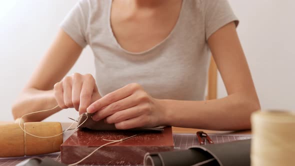 Woman making leather wallet