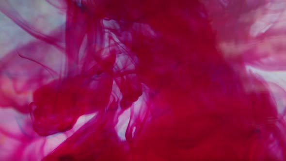 Red ink slowly moving through water alt