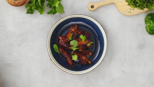 Crop person adding spices to barbecue ribs