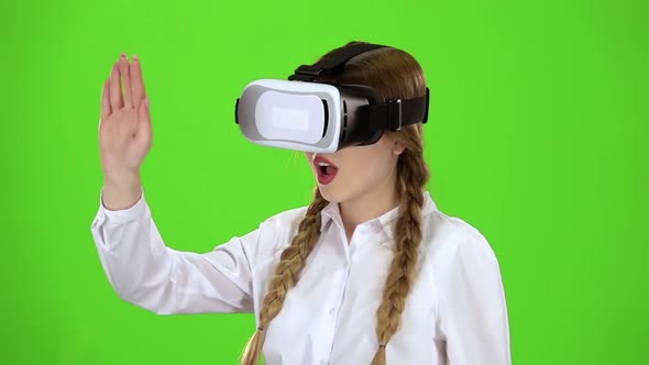 Girl in Virtual Reality Glasses Is Watching an Exciting Video Green Screen. Slow Motion