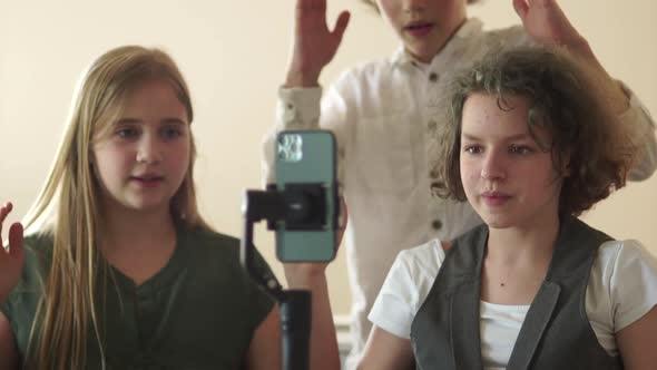 Portrait of Funny Schoolkids Bloggers Curlyhaired Teenage Boy and Girls with a Steadicam