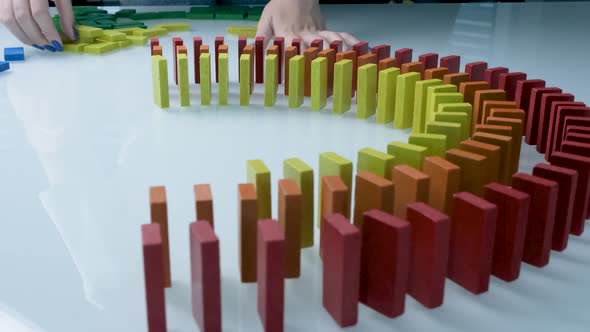 Line up of Dominoes in Rainbow Falling Colors with LGBT Colors of a Hand