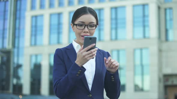 Happy Young Lady Scrolling on Smartphone Receiving Job Offer, Successful Startup