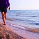 A Girl Walks Along the Coast Along the Edge of the Sea - VideoHive Item for Sale