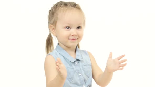 Child Sits on the Floor and Claps His Hands. White Background