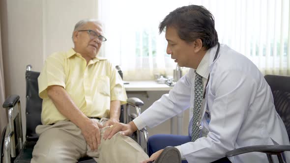 Orthopedist examines the knee of elderly patient to collect information for physical therapy treated