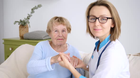 Smiling Woman Doctor Reassuring Her Senior Female Patient