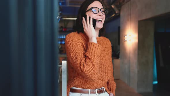 Positive red haired woman talking by mobile