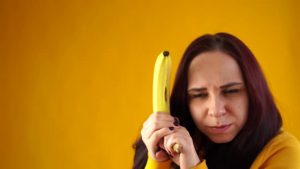Portrait of Young Woman with Banana on Yellow Background