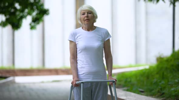 Sad Old Female With Walking Frame at Sunny Hospital Park, Ineffective Treatment