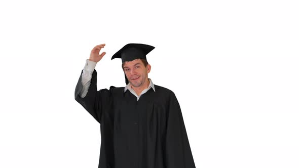 Smiling Male Graduate Throwing His Graduation Hat in the Air and Raising His Diploma on White