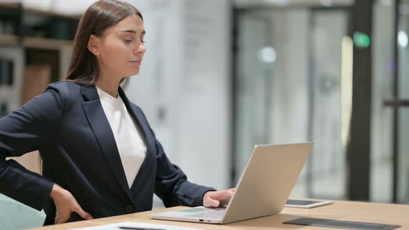 Businesswoman with Laptop Having Back Pain 