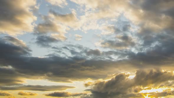 Time lapse of fast moving clouds on dark blue sky at sunset.