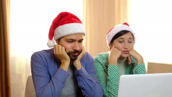 Loving Multiracial Couple Man and Woman in Santa Hats are Smiling and Hugging Talking By Online