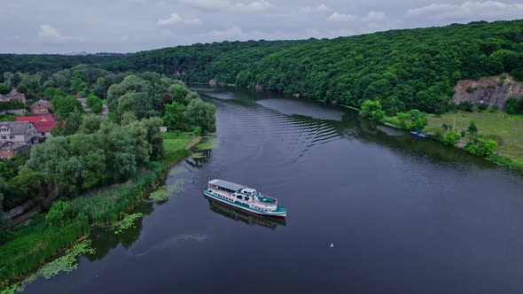 A Small Passenger Ship Sails on the River