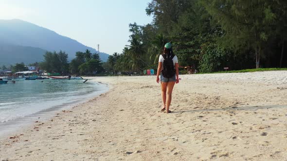 Women tanning on tranquil lagoon beach time by aqua blue ocean with white sandy background of Koh Ph