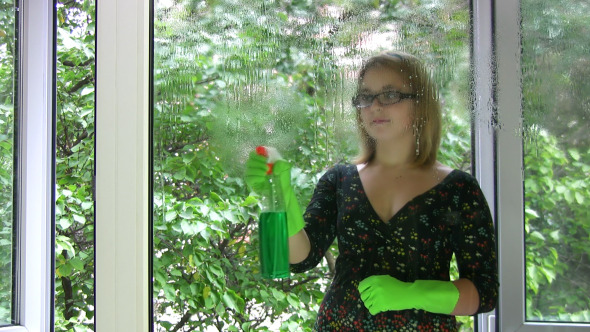 Girl Washing Window And Shows Tongue