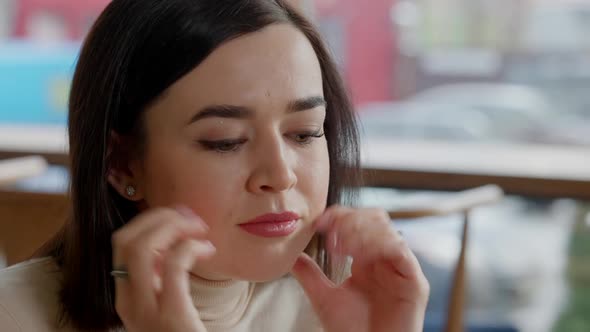 Closeup of Worried Young Caucasian Woman Holding Head in Hands Thinking