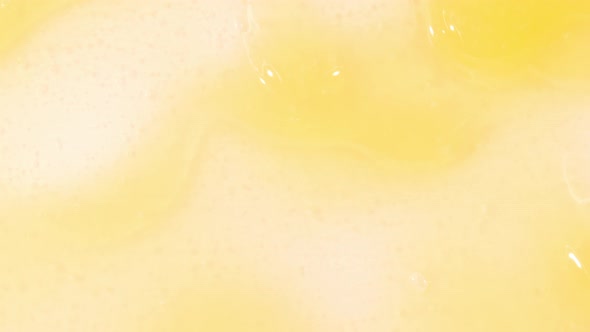 Yellow Cosmetic Gel Fluid Flowing Down on a White Surface