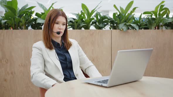 Businesswoman Giving Online Consultation Using Headset and Laptop