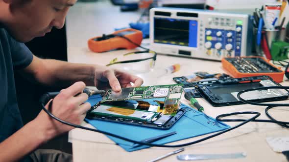 Technician Fixing Circuit Board Using Electronics Repair Tools Kit