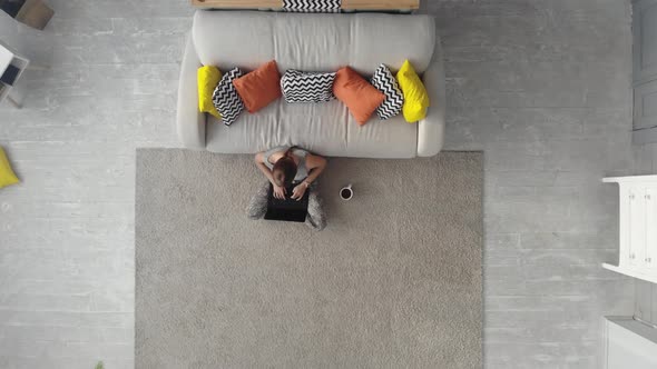 Top View. Woman Working on Laptop at Home.