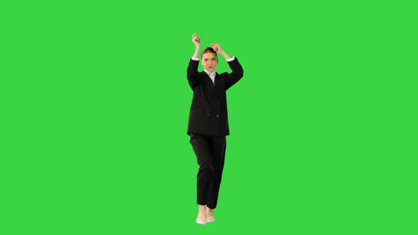 Young Woman in Office Suit Walks Dancing Raising Her Arms on a Green Screen Chroma Key