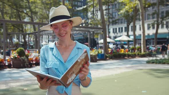 Smiling woman with a travel book in New York
