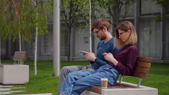 Two friends using smartphones outdoor park