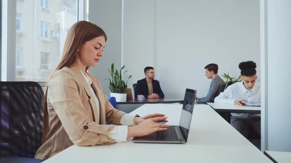 Female Employee Working on Laptop in Office