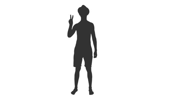 Silhouette of Young Man in Shorts and Hat Doing Peace or Victory Sign