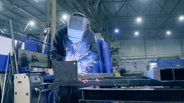 Male Welder in a Protective Mask Is Processing Metal. Professional Heavy Industry Welder Working at