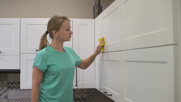 Girl Wipes the Kitchen with a Rag