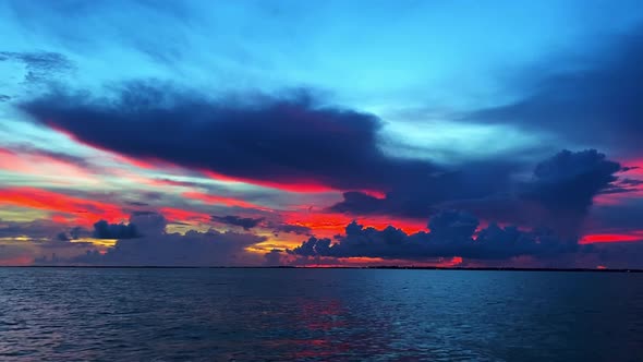 Clip over the ocean with cloudline in the horizon revealing beautiful colors during sunset in Florid