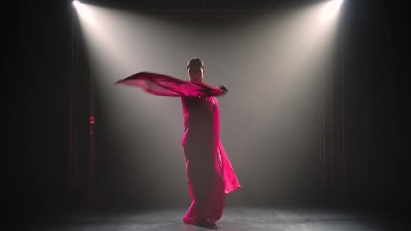 Silhouette a Young Girl Dancer in a Red Sari. Indian Folk Dance. Shot in a Dark Studio with Smoke