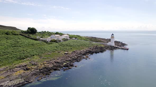 A Lighthouse on an Island with a Jetty and Ferry