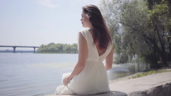 Portrait Charming Young Girl with Long Brunette Hair Wearing a Long White Summer Fashion Dress