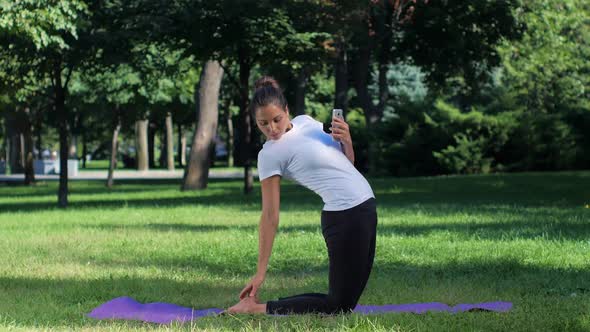 Girl Doing Selfie with Smart Phone in the Yoga Position