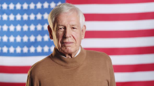 Portrait of Senior Caucasian Man Posing on American Flag