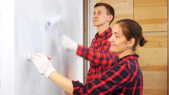 Woman with Brush and Man with Roller Paint Wall on Terrace