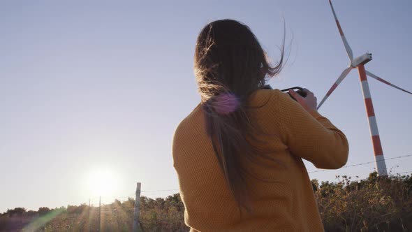 Filmmaker woman filming wind turbines