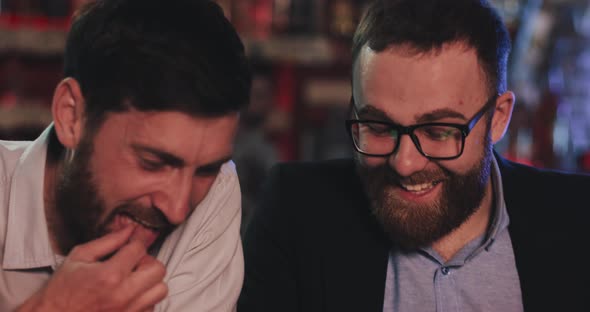 Two Old Friends with Smartphone Talking in the Beer Pub at Night