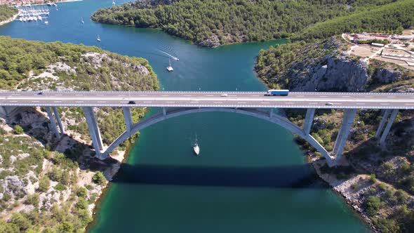 Flying over Krka river, autostrada and arch bridge at summer in Croatia, Europe