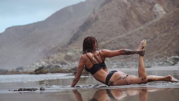 Beautiful Woman in Swimsuit Dancing While on the Beach with Black Sand Near the Ocean Canary Islands