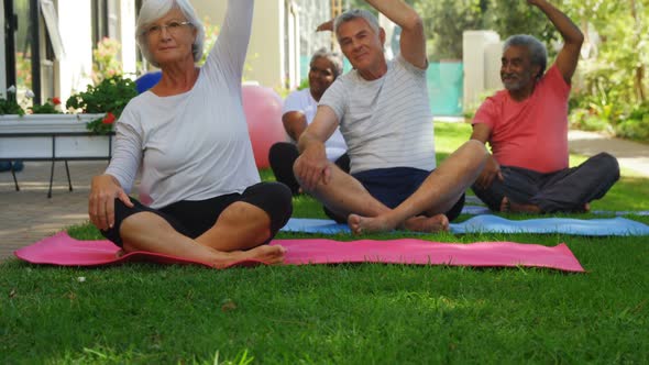 Senior friends doing exercise in garden 4k