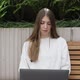 Young Female in Garden Using Laptop Communicates on Internet with Customer - VideoHive Item for Sale