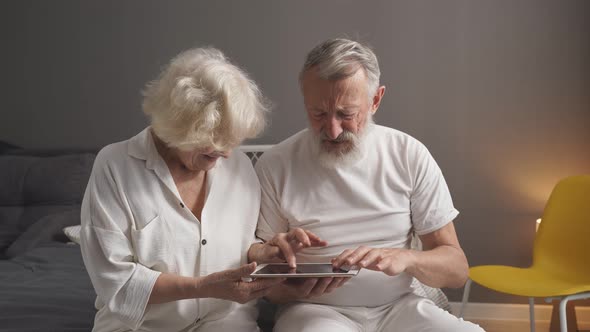 Elderly Caucasian Man and Woman Play Online Games Look at the Screen