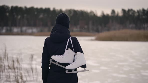 A Young Woman in a Dark Jacket, Came To the Frozen Lake To Go Ice Skating. In Winter, Nature Can Be