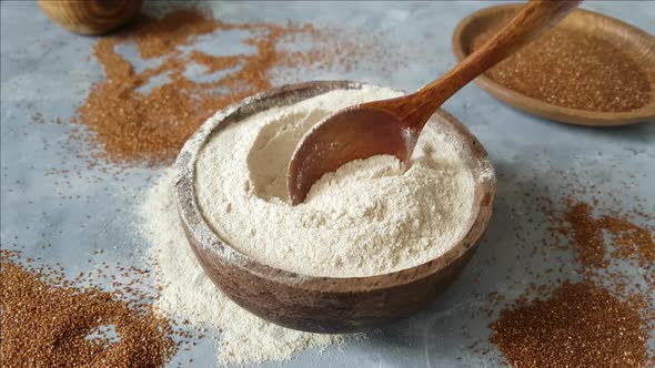 Teff flour in a bowl with a spoon and teff grain
